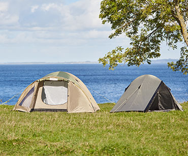 Beige telt og grønt telt på græsplæne