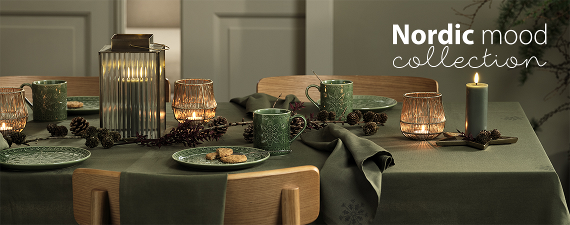 Yeşil yılbaşı tabakları, yeşil yılbaşı kupaları, fener vetealight mumluklar ve mumlarla hazırlanmış masa düzeni