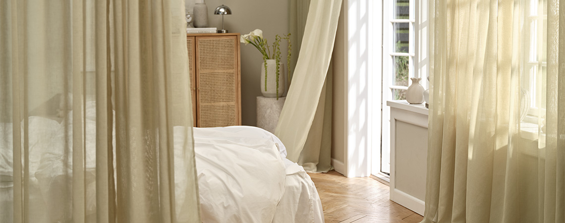 Yemek odasındaki pencerelerin önünde perde çubuklarına asılı perdeler