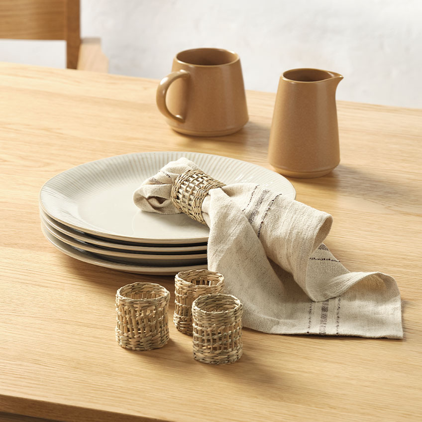 Milk jugs, cloth napkin, and napkin rings on dining table
