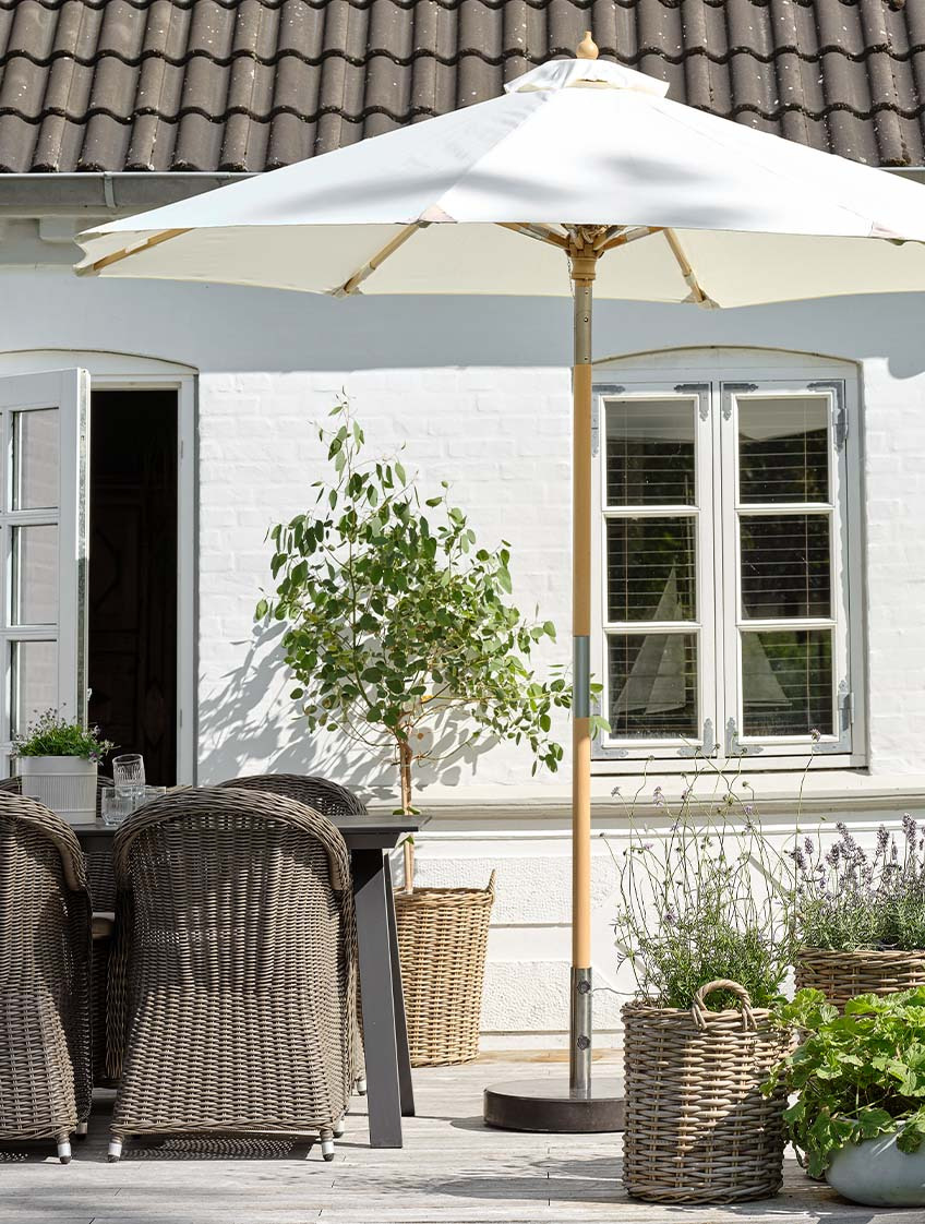 Bahçe masası ve bahçe sandalyeleri ile verandada klasik kırık beyaz bahçe şemsiyesi