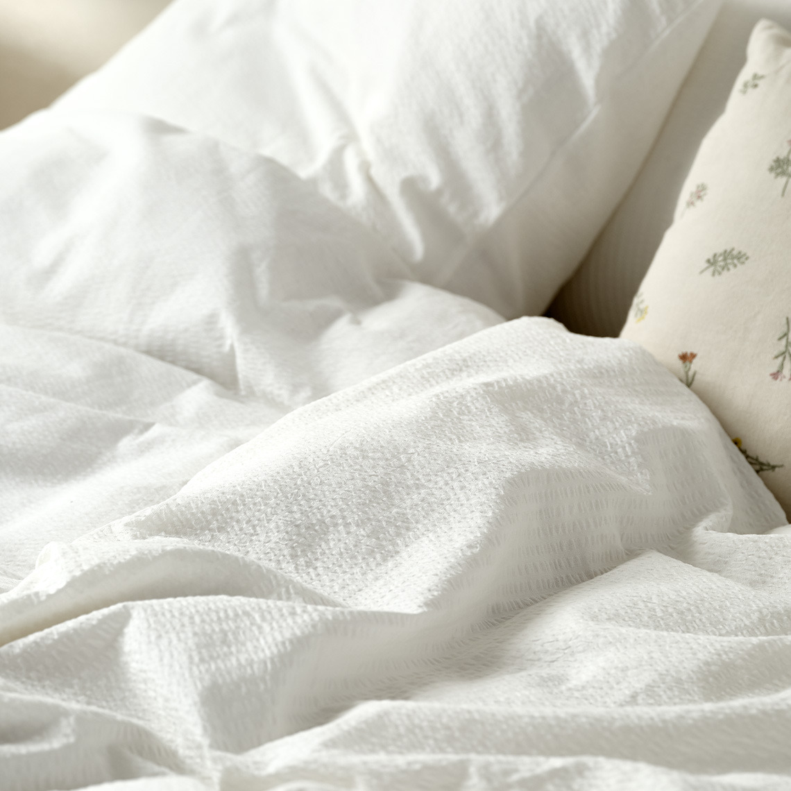 Bedding made from seersucker fabric is great for staying cooler throughout the night White seersucker bedding on bed