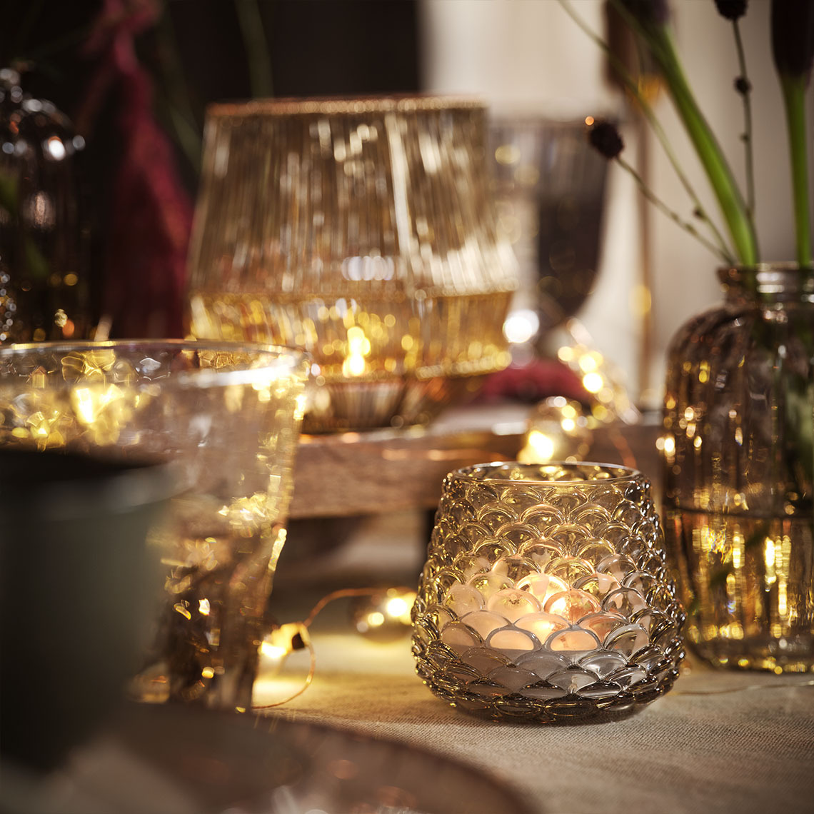 BIFROST tealight mumluk Mumluklarda duran mumlar, tealight'lar ve LED ışık dizileriyle aydınlatılmış yemek masası