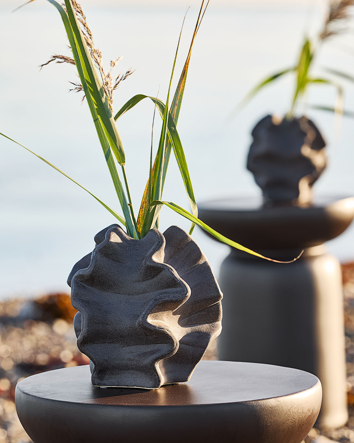 Sahilde bir kaide üzerinde duran organik formlu vazo