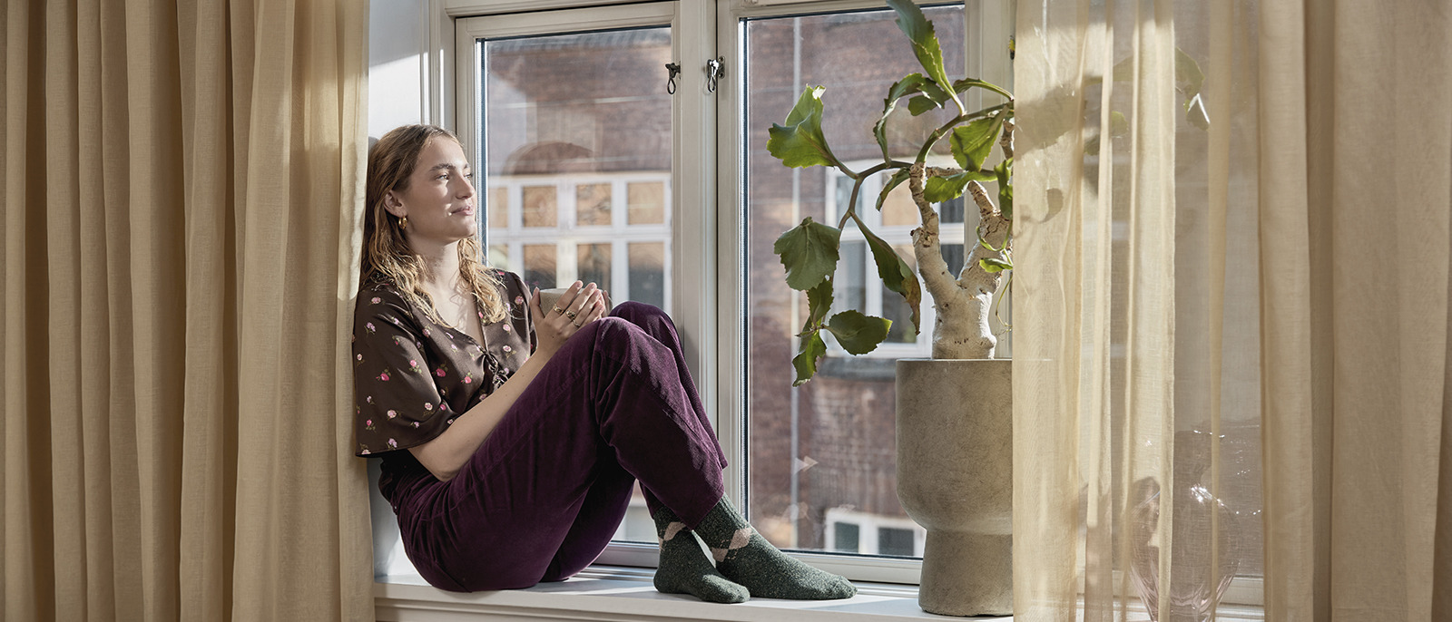 Camdan dışarı bakan kadın ve perde